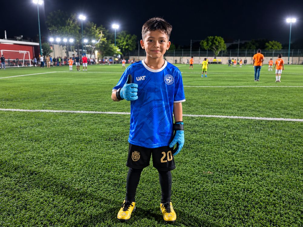 Portero del Corre Cancún con guantes en un partido nocturno